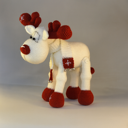 Knitted reindeer toy with red antlers and hooves on a plain background