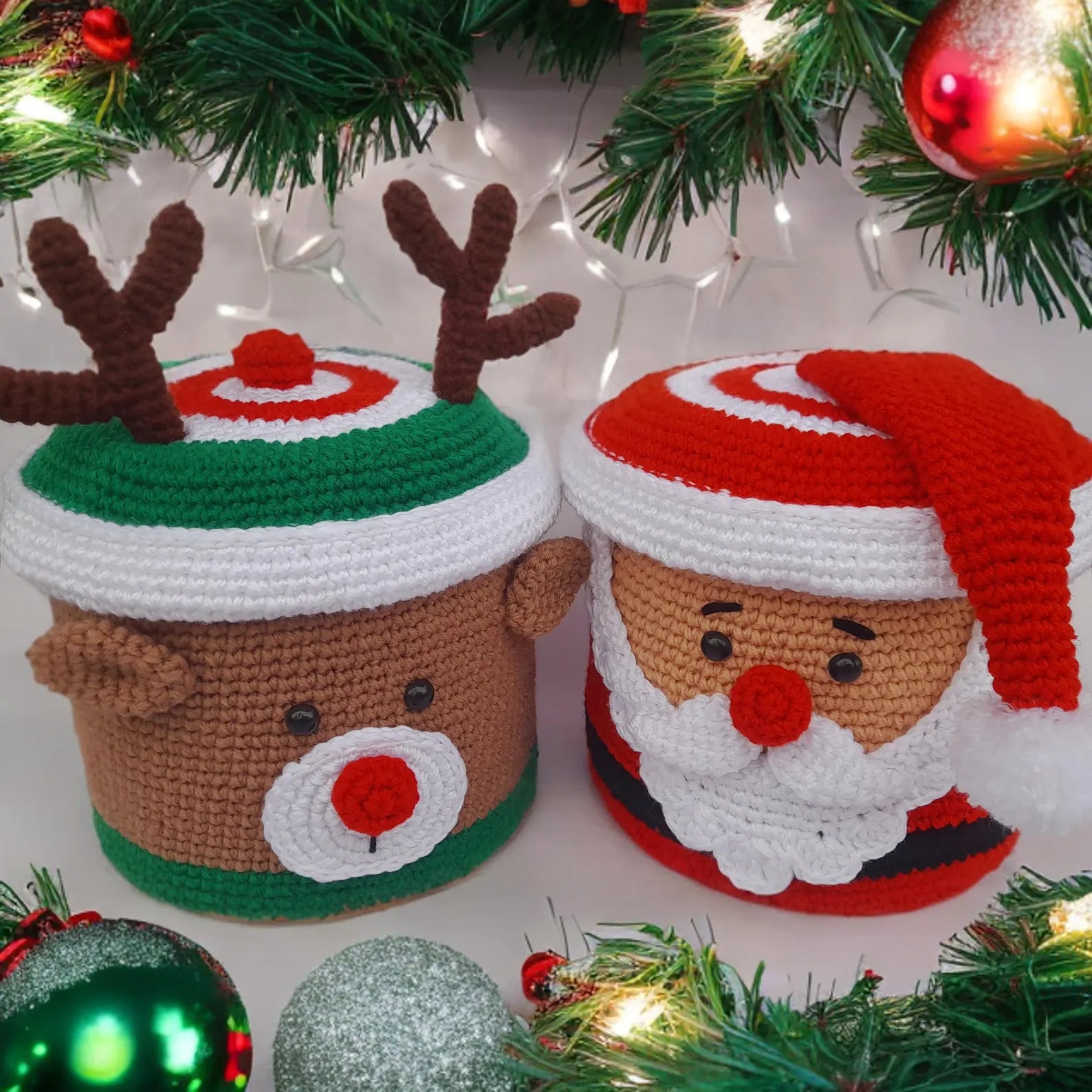 Two crocheted Christmas ornaments shaped like a reindeer and Santa Claus, surrounded by festive decorations.