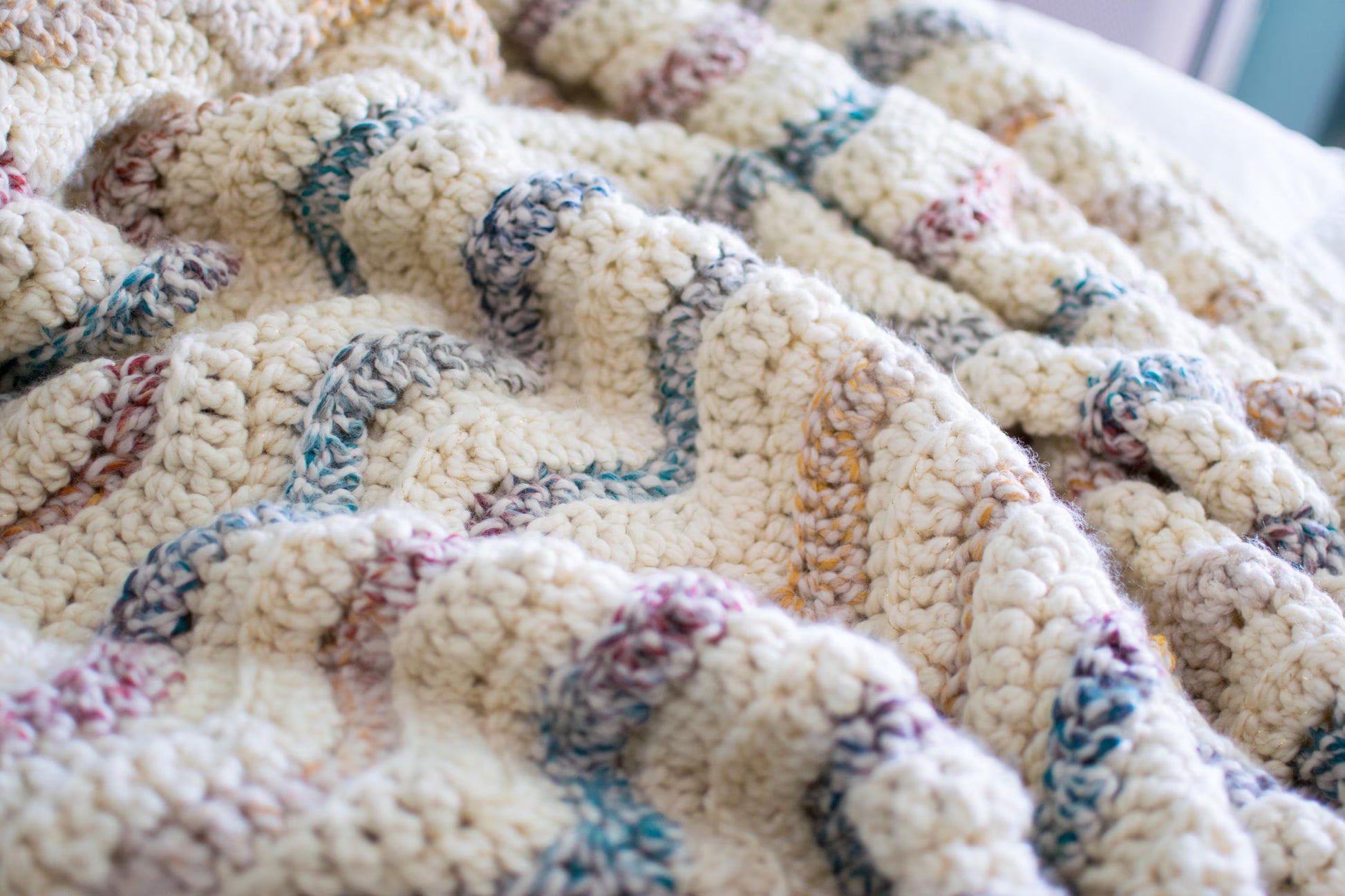 Close-up of a textured blanket with multicolored patterns on a white background