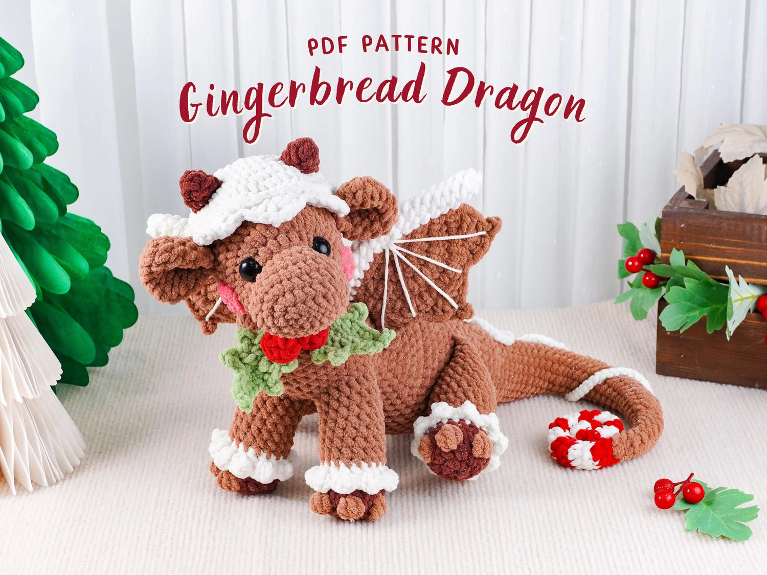 Crocheted gingerbread dragon toy with Christmas decorations on a white background